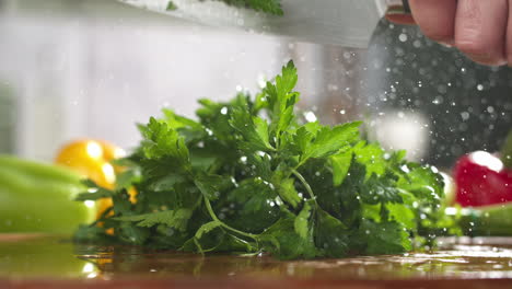 Slow-motion-of-parsley-chopped-with-a-knife-on-wooden-board-in-a-kitchen
