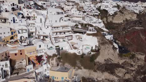 Fliegen-In-Richtung-Der-Weißen-Häuser-Von-Santorini,-Griechenland