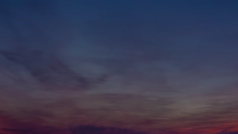 Timelapse-of-clouds-colored-by-the-setting-sun-moving-over-the-horizon