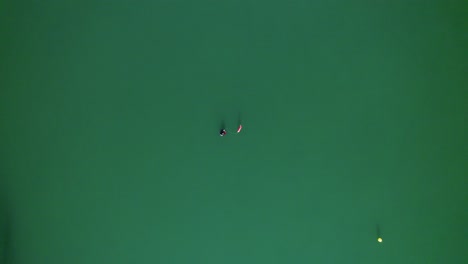 Aerial-view-of-a-diver-in-the-middle-of-a-green-lake,-alone-in-the-world