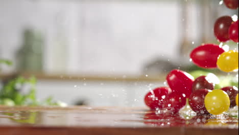 Slow-motion-of-mix-of-cherry-tomatos-falling-on-wet-wooden-board-in-a-kitchen