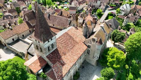 Small,-medieval-village-situated-next-to-a-river,-flowing-through-a-rich-forest-in-the-heart-of-France