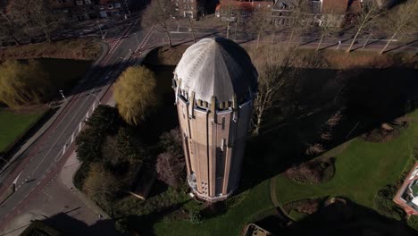 Top-down-and-dramatic-aerial-rotating-pan-of-former-Dutch-brick-water-tower-in-Zutphen-now-repurposed-as-a-residential-home