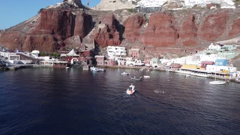 Luftaufnahme-Eines-Bootes,-Das-Sich-Dem-Pier-Von-Ammoudi-In-Der-Stadt-Oia-Auf-Santorini,-Griechenland,-Nähert