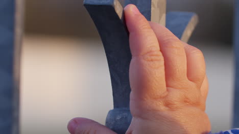 Close-up-shot-of-a-child-touching-a-metal-fence-and-feeling-the-material