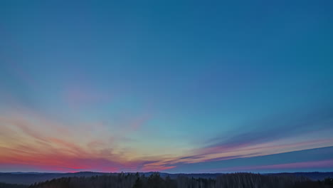 Timelapse-of-a-clouds-in-different-colors-during-a-sunset-over-an-nature-reserve