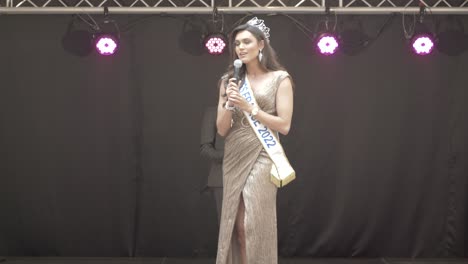 Miss-France-2022-at-the-microphone-on-stage-in-the-south-of-France,-she-wears-her-crown-and-her-scarf