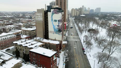 Aerial-view-of-the-President-Lincoln-mural-on-a-hotel-in-wintry-Chicago,-USA---descending,-drone-shot