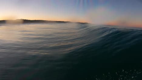 Surfeando-Una-Ola-Haciendo-Un-Flotador-Con-Una-Go-Pro-En-La-Boca-En-Un-Fantástico-Amanecer-En-Cascais,-Portugal
