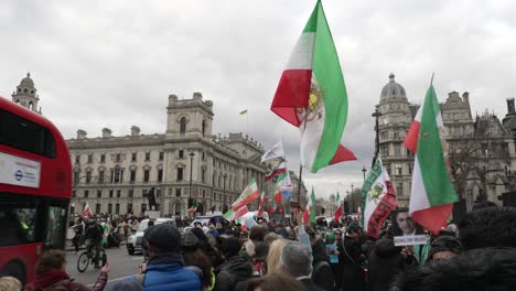 27-February-2023---Large-Iran-Flag-Being-Held-And-Waved-By-British-Iranians-Protesting-On-Parliament-Square