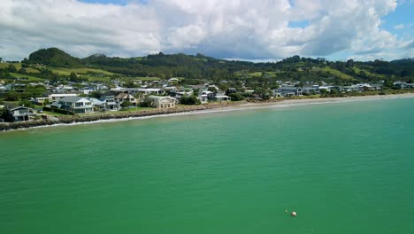 Aerial-view-of-beach-front-luxury-properties-in-Cooks-Beach,-New-Zealand