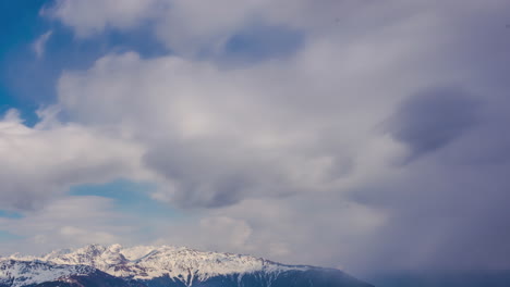 Schauer-Ziehen-über-Schneebedeckte-Berggipfel-In-Den-Alpen