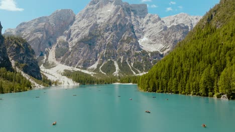Aerial-shot-of-a-drone-above-the-river-with-the-Dolomites-Alps-in-the-back,-Lago-di-Braies,-Italy,-Dolomites