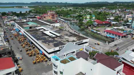 Vista-Aérea-Giratoria-De-Un-Concurrido-Mercado-Público-Frente-Al-Mar-En-Virac,-Catanduanes,-Filipinas