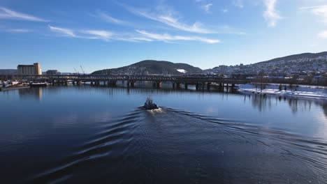 А-boat-sailing-in-the-river-in-Drammen,-Norway