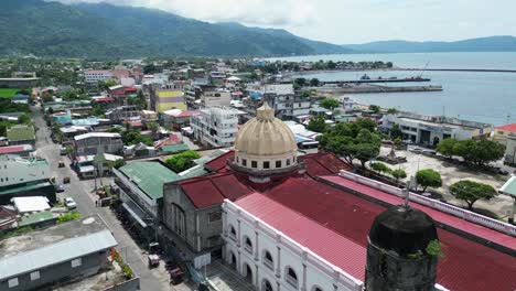 Rotating-Aerial-Drone-Shot-of-Vintage-Cathedral-Church-in-center-of-seafront-town-Virac,-Catanduanes
