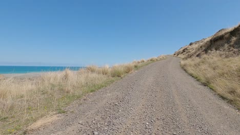 POV-Off-Road-Cycling-uphill-from-sea-side-settlement-on-a-beautiful-summer's-day---Bossu-Road,-Canterbury