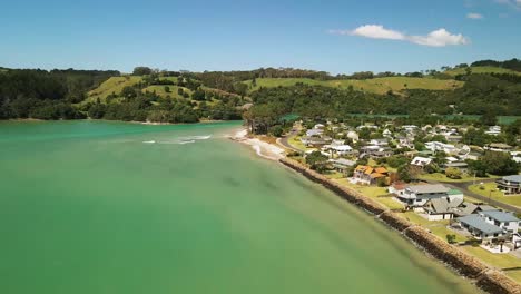 Drohne-Steigt-über-Bach-Ferienhäusern-Am-Strand-In-Neuseeland-Auf