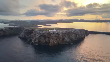 Cavalleria-Leuchtturm-Nördlich-Von-Menorca-Mit-Sonnenuntergang-Zwischen-Den-Wolken