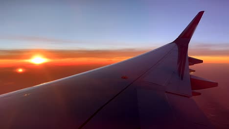 Timelapse-plane-wing-flying-with-beautiful-sunset-in-sky-over-Africa