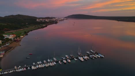 Small-marina-in-Fornells-Bay,-Menorca-Spain-with-sailing-yachts-floating-as-drone-flys-over