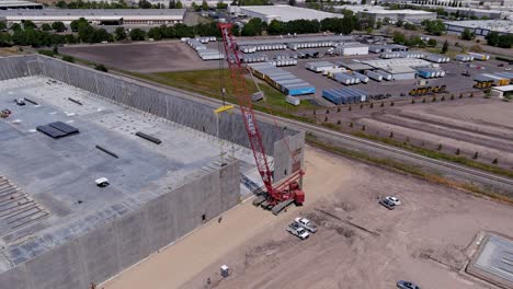 A-high-orbiting-shot-of-a-crane-lifting-a-concrete-wall-into-place-in-a-commercial-building