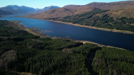 Vuelo-Lento-A-Gran-Altitud-Sobre-Un-Denso-Bosque-De-Pinos-Hacia-Loch-Loyne-Scottish-Highlands
