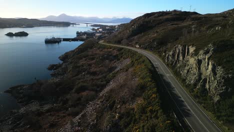 Deserted-road-to-Kyle-of-Lochalsh-with-Skye-bridge-and-Cuillin-mountains-in-Scottish-Highlands