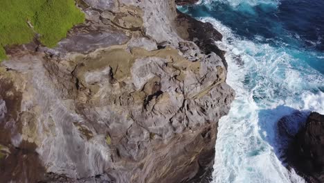 Wunderschöne-Krachende-Blaue-Wellen-In-Der-Spitting-Cave-In-Honolulu,-Hawaii,-Mit-Zerklüfteten-Klippen-Und-Lebendigem-Grün---Luftaufnahme-Von-Oben-Nach-Unten