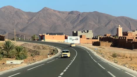 Conduciendo-A-Través-De-La-Ciudad-Rural-En-Marruecos-Con-Las-Montañas-Del-Atlas