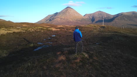 Hiker-and-slow-pan-across-Red-Cuillin-mountains-at-dawn-on-the-Isle-of-Skye-Scotland