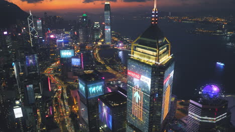 Toma-Aérea-De-Pájaros-De-Iluminación-De-Edificios-Rascacielos-En-La-Ciudad-De-Hong-Kong-Con-Gráfico-De-Movimiento-De-Holograma-De-Noticias-De-última-Hora-En-La-Noche---Conectando-El-Concepto-Futurista-Con-El-Diagrama-Digital