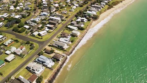 Aerial-drone-flight-along-shoreline-of-Cooks-Beach,-Coromandel-Peninsula---New-Zealand