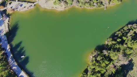 Top-down-reveal-of-Lake-Mpeletsi-in-Greece-on-a-sunny-day