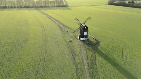 Pitstone-windmill-aerial-rising-view-orbiting-tourists-walking-around-idyllic-sunlit-wooden-Buckinghamshire-landmark