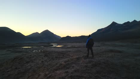 Pan-from-Black-Cuillin-to-Red-Cuillin-at-dawn-with-hiker-on-Isle-of-Skye-Scotland