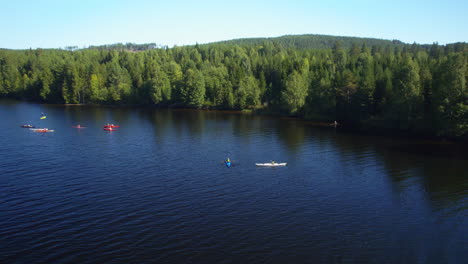 group-of-people-in-kayaks-paddling-on-a-river-in-the-sun