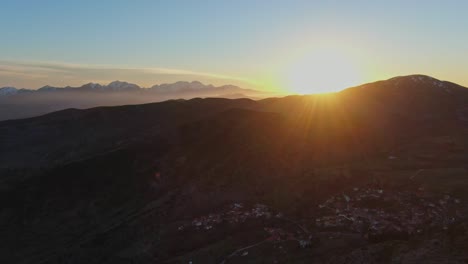 Pueblo-Griego-Con-Montañas-Y-Puesta-De-Sol-En-El-Fondo