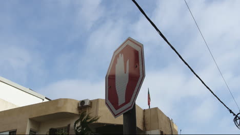 A-stop-sign-in-the-middle-of-a-street-with-a-bright-blue-sky-and-electricity-cords-in-the-background