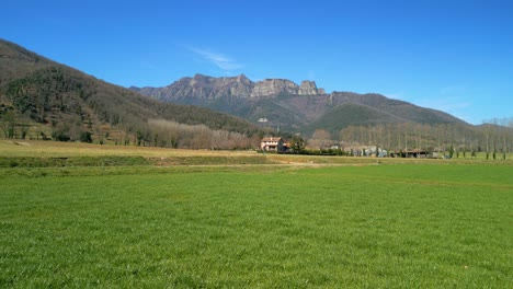 Espectacular-Imagen-De-La-Garrotxa-En-Un-Campo-Verde-Cultivado-Y-Montañas-Al-Fondo-En-Girona-España-Turismo-Europeo-Desliza-A-La-Derecha