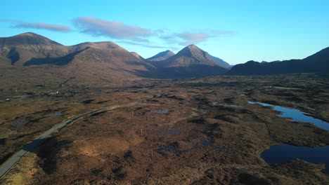 Highland-road-reveal-with-minimal-traffic-and-Red-Cuillin-mountains-at-dawn-at-Sligachan-on-the-Isle-of-Skye-Scotland