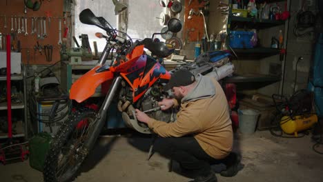 Man-fixing-a-motorbike-in-a-garage