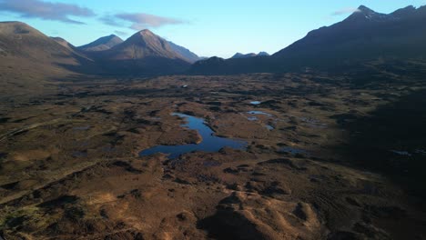 Flying-over-Scottish-moorland-towards-loch-and-Cuillin-mountains-in-dawn-light-at-Sligachan-on-the-Isle-of-Skye-Scotland