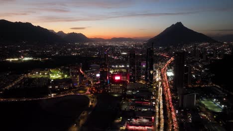 Aerial-overview-of-the-illuminated-cityscape-of-San-Pedro-Garza-Garcia,-Monterrey,-colorful-evening-in-Mexico