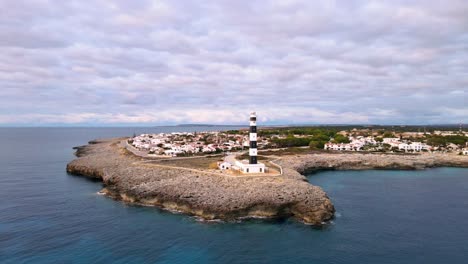 Artrutx-lighthouse-sitting-at-the-end-of-rocky-clifftop-in-Menorca,-Spain