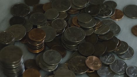 Slow-spin-over-a-large-pile-of-American-change-in-a-dark-room
