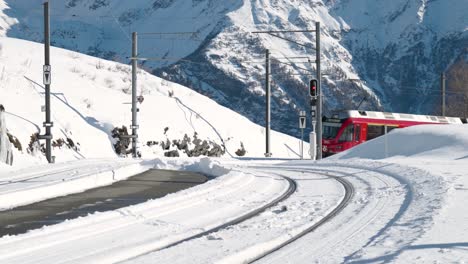 Red-panorama-train-passing-on-a-sunny-day-in-the-mountains-in-Alp-Grum,-Switzerland