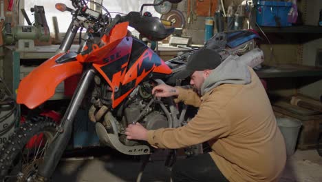 Mann-Arbeitet-An-Einem-Dirtbike-In-Einer-Garage