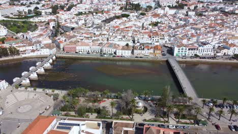 Drone-flight-over-Tavira-Algarve-Portugal,-the-old-town-plaza-and-river,-a-warm-sunny-day-in-early-spring,-a-panning-shot-of-the-town-centre