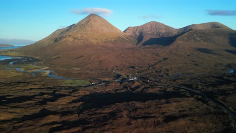 High-level-approach-to-hotel-at-Sligachan-with-sunlit-Red-Cuillin-mountains-at-dawn-on-the-Isle-of-Skye-Scotland